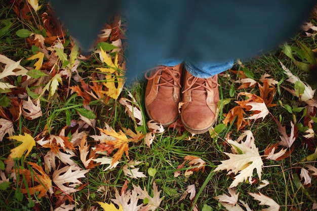 Fußjunge, der in den Herbstpark geht