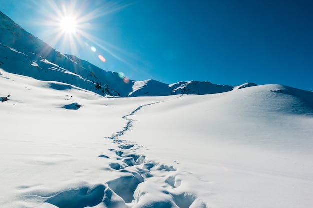 Fußspuren in der Neuschneeberglandschaft Schöner Wintersonnenaufgang Abenteuer- und Reisezeit