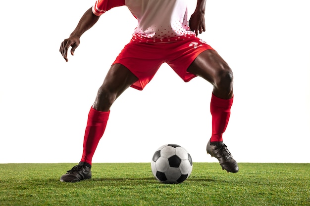 Fútbol americano africano profesional o jugador de fútbol del equipo rojo en movimiento aislado sobre fondo blanco de estudio. Colocar al hombre en acción, emoción, momento emocional. Concepto de movimiento en el juego.