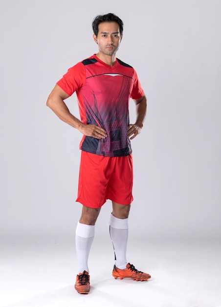Futbolista masculino con uniforme atlético y zapatos parados en una postura segura según la personalidad del atleta