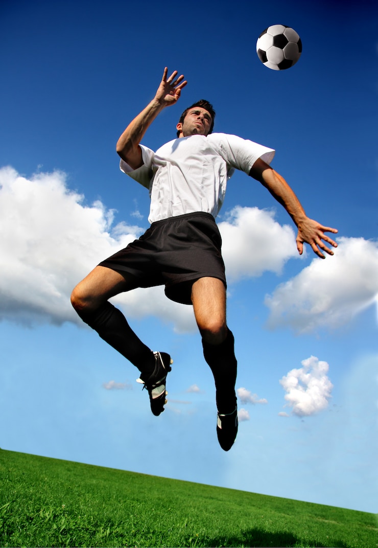 Foto futbolista o futbolista en posición acrobática.