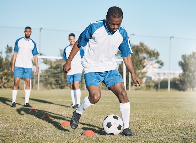 Futebol esportivo e homem negro treinando com bola para prática de jogo e exercício em campo ao ar livre Energia de motivação e jogador de futebol masculino chutam correndo e marcam gols para exercícios físicos