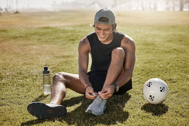 Foto futebol esportivo e sapatos de gravata masculina antes da competição do jogo ou exercício físico no campo de grama ao ar livre bola de saúde de bem-estar e jogador de futebol atleta se preparam para treinamento ou cardio