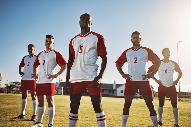 Futebol futebol e retrato de equipe ou grupo em campo juntos prontos para um jogo ou competição Diversidade de fitness e homens ou jogadores no campo de grama se preparando para treino ou treinamento esportivo