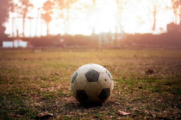 Futebol sujo ao pôr do sol, escola de campo de futebol rural