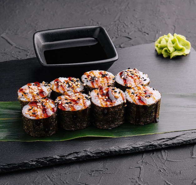 Futomaki de sushi japonés fresco tradicional en piedra negra