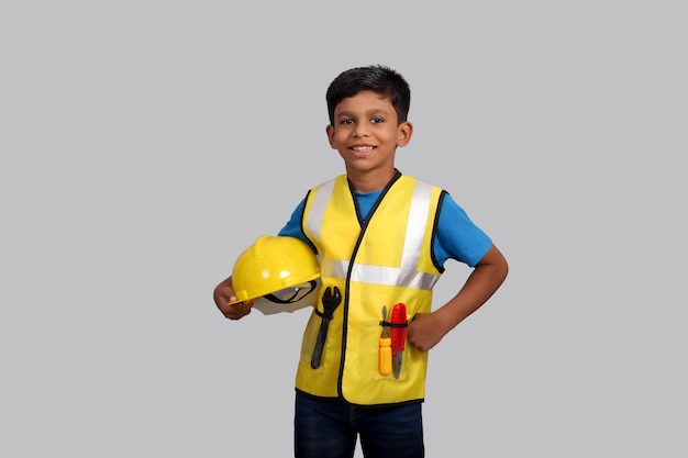 Foto futuro arquitecto indian boy vistiendo uniforme de gerente de construcción y casco de pie