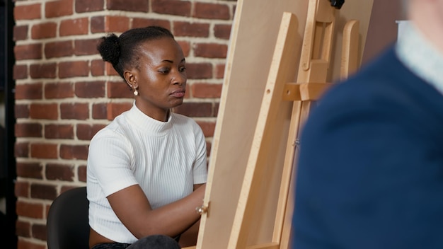 Futuro artista desenhando esboço profissional na tela com cavalete na aula de arte. Programa artístico para desenvolver novas habilidades e desenhar obras de arte com modelo de inspiração para o crescimento educacional.