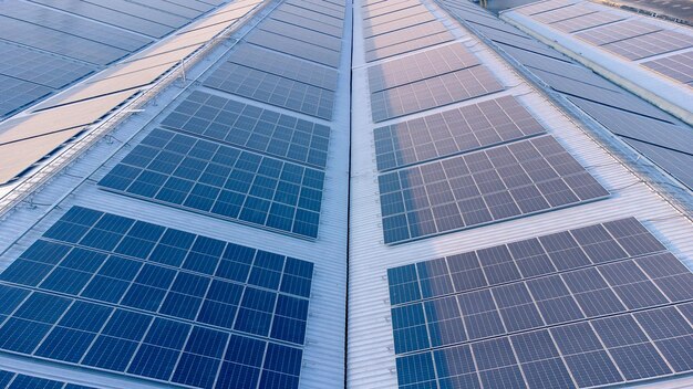 Futuro concepto de energía verde y recursos de electricidad sostenible Foco exterior en paneles solares en tejados o fotovoltaicos de fábricas por drones Techo industrial con rejilla de células solares con tono azul