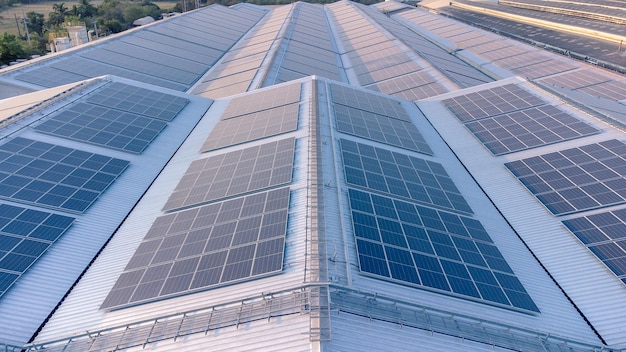 Futuro concepto de energía verde y recursos de electricidad sostenible Foco exterior en paneles solares en tejados o fotovoltaicos de fábricas por drones Techo industrial con rejilla de células solares con tono azul