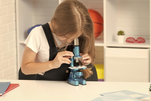 Futuro garoto cientista olhando através do escopo aproveitar a ciência do método científico e a infância