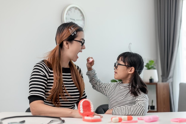 Futuro médico revisando la dentadura de la madre en el hogar