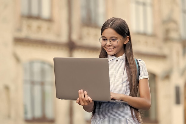 Futuro programador bem-sucedido dia do conhecimento criança aprendendo lição particular blogs infantis garota sorridente feliz com laptop Inicie a criança jogando jogo de computador de volta à educação escolar on-line