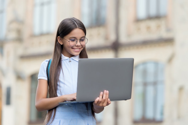 Futuro programador de sucesso. dia do conhecimento. criança aprendendo aula  particular. blogging infantil. garota feliz e sorridente com o laptop.  comece. criança jogando jogo de computador. de volta à escola. educação  online.