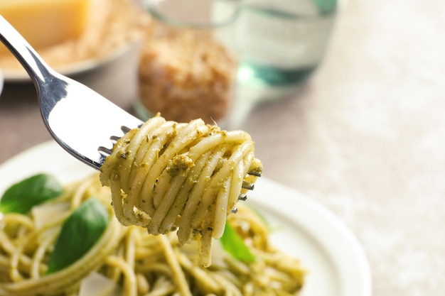 Gabel mit köstlichen Basilikum-Pesto-Nudeln über Teller-Nahaufnahme