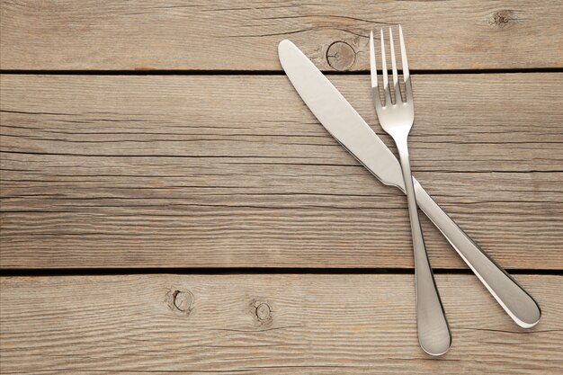 Gabel und Messer auf einem Holztisch