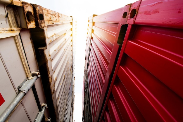 Foto gabelstapler, der frachtcontainer im versandhof oder dockyard gegen sonnenaufganghimmel anhebt, mit frachtcontainerstapel im hintergrund für transportimport, -export und logistisches industriekonzept