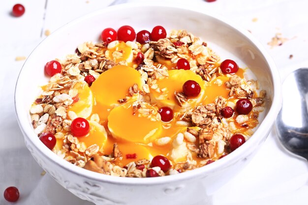 Gachas de arroz de desayuno saludable con puré de mango, plátano y granola