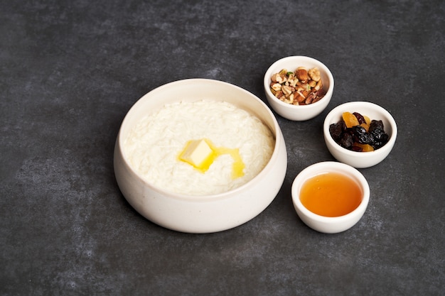 Gachas de arroz con leche, pasas, miel y nueces en un tazón.