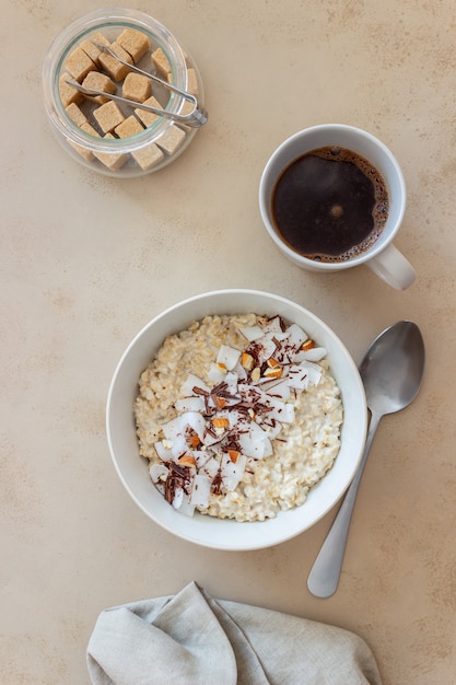 Gachas de avena con almendras, coco y chocolate. Alimentación saludable. Comida vegetariana. Desayuno. Dieta.