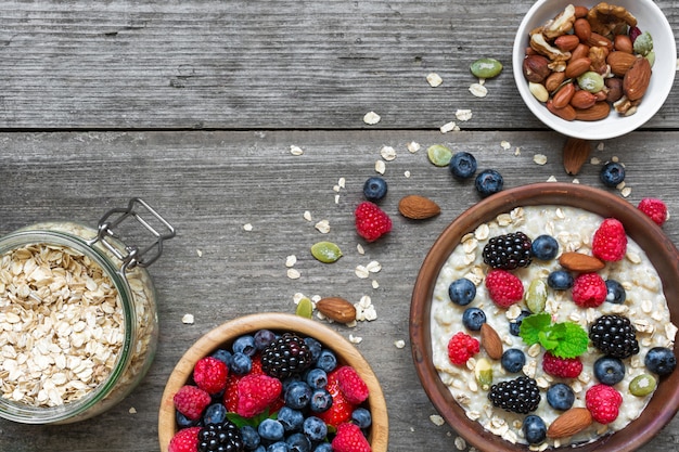 Gachas de avena con arándanos frescos, frambuesas, nueces, semillas y muesli