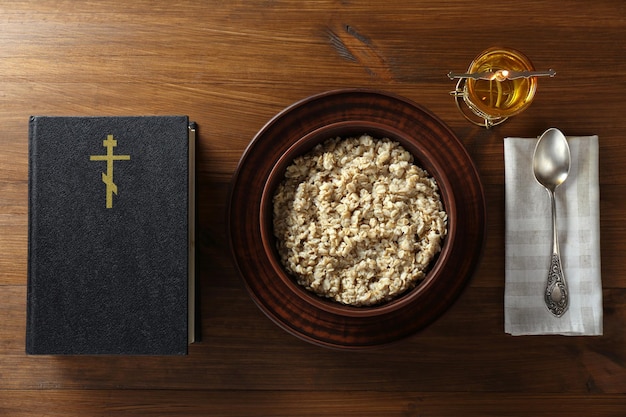 Gachas de avena de la Biblia y una cuchara en la mesa de madera plana la temporada de Cuaresma