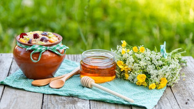 Gachas de avena de frutas con miel en un picnic.