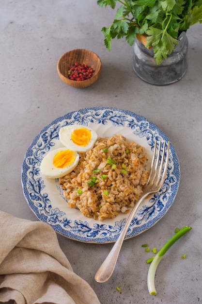 Gachas de avena gruesa con huevos y cebolla. Concepto de desayuno o almuerzo saludable abundante. Enfoque selectivo.