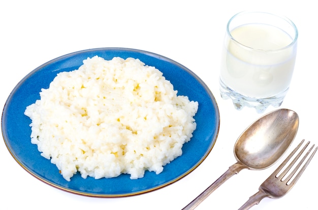 Gachas de avena de leche de arroz delicioso en placa azul aislada.