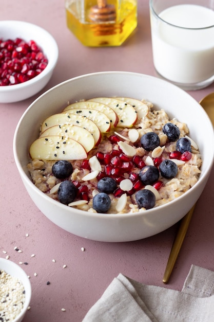 Gachas de avena con manzana, granada, arándanos y almendras. Alimentación saludable. Comida vegetariana. Desayuno.