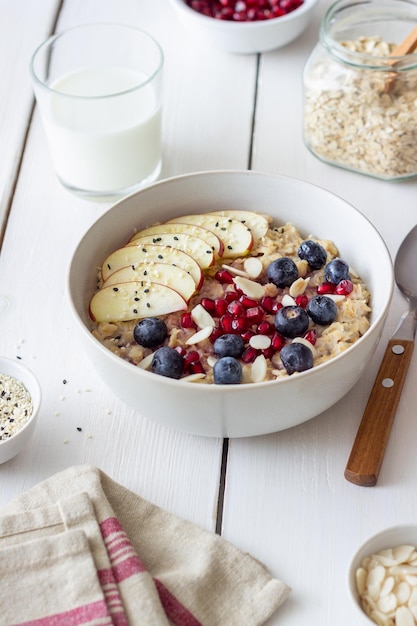 Gachas de avena con manzana, granada, arándanos y almendras. Alimentación saludable. Comida vegetariana. Desayuno.