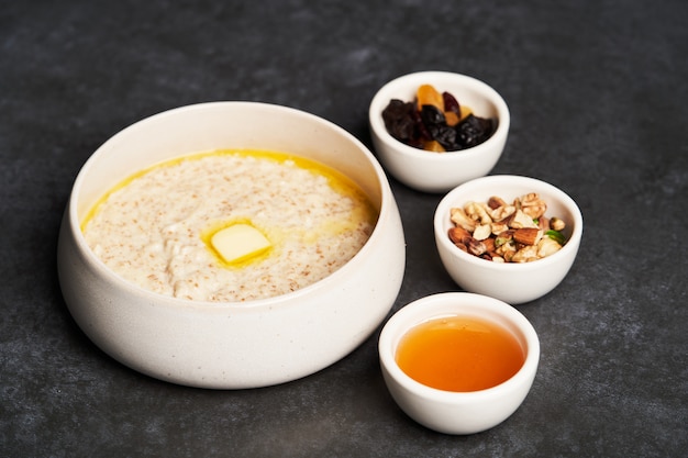 Gachas de avena con pasas, miel y nueces en un tazón