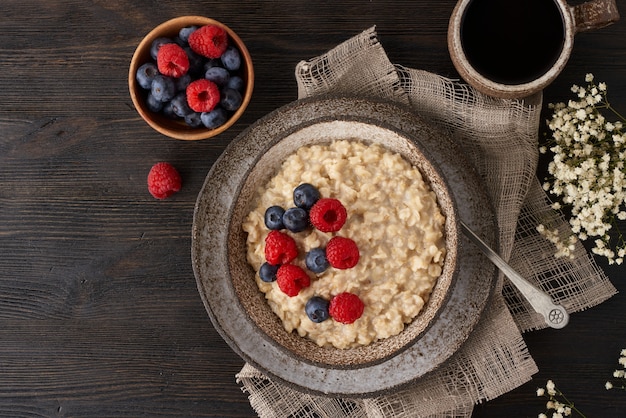 Gachas de avena rústica con arándanos, frambuesas en un tazón de cerámica vintage