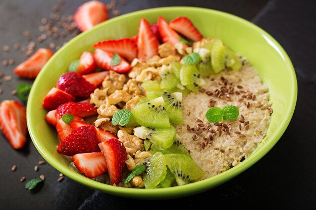 Gachas de avena sabrosas y saludables con bayas, nueces y semillas de lino.