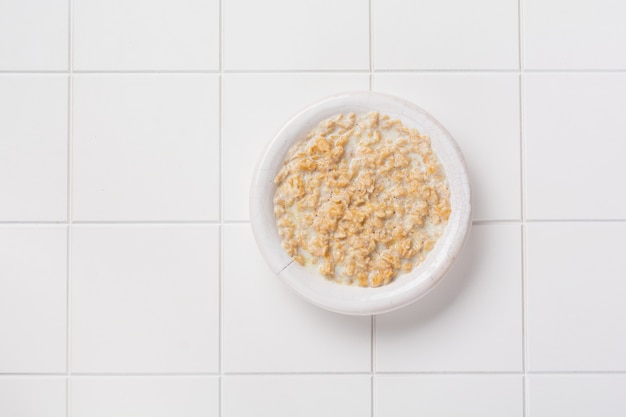 Gachas de avena simple con fresas en un plato blanco sobre una servilleta de lino