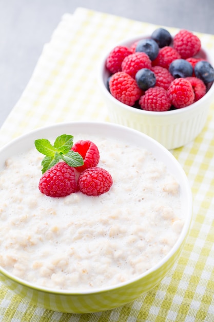 Gachas de avena en un tazón con frambuesas y moras.