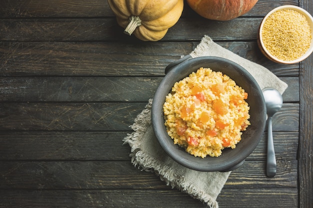 Foto gachas de mijo con calabaza dulce en un bol, estilo rústico. plato vegano saludable. vista superior