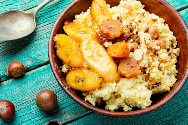 Gachas de mijo con plátanos caramelizados y nueces desayuno saludable.