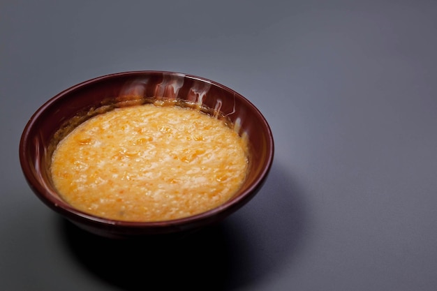 Gachas de trigo con leche de almendras sobre fondo de color gris oscuro