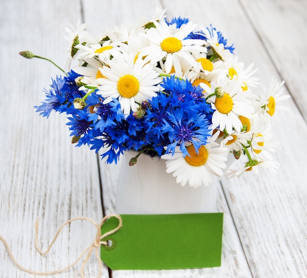 Gänseblümchen und Kornblumen in der Vase