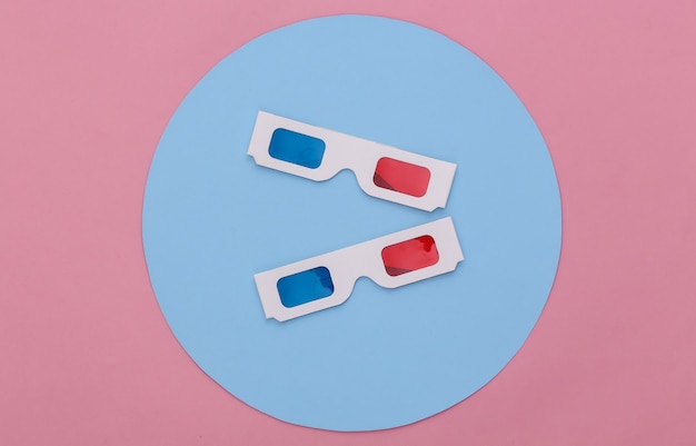 Gafas 3D anaglifo sobre fondo rosa con un círculo azul. Foto de estudio conceptual. Minimalismo. Vista superior