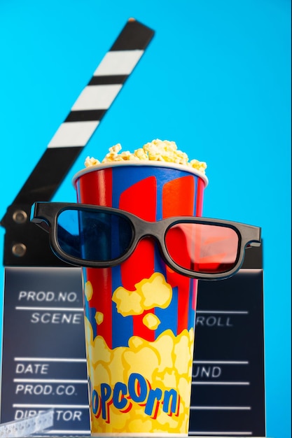 Foto las gafas 3d de popcorn y el carrete de película sobre fondo azul diseño de collage