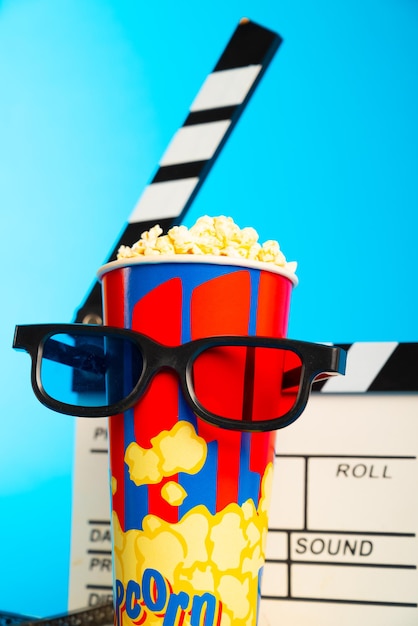 Foto las gafas 3d de popcorn y el carrete de película sobre fondo azul diseño de collage