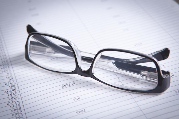 Gafas con bolígrafo de cerca y concepto de contabilidad de informes financieros