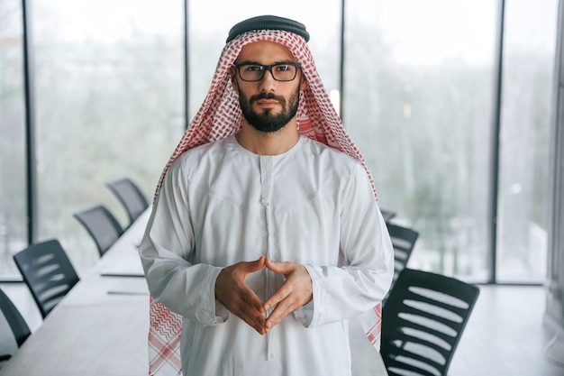 En gafas exitoso hombre de negocios musulmán en traje tradicional en su oficina