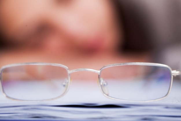 Gafas en el fondo de un trabajador cansado que se quedó dormido en la mesa