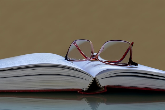 Gafas de lectura en libro abierto y espacio para texto.