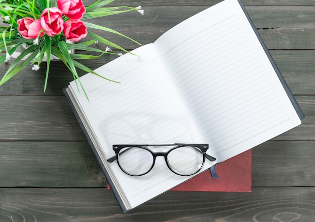 Gafas de lectura en libro abierto sobre mesa de madera