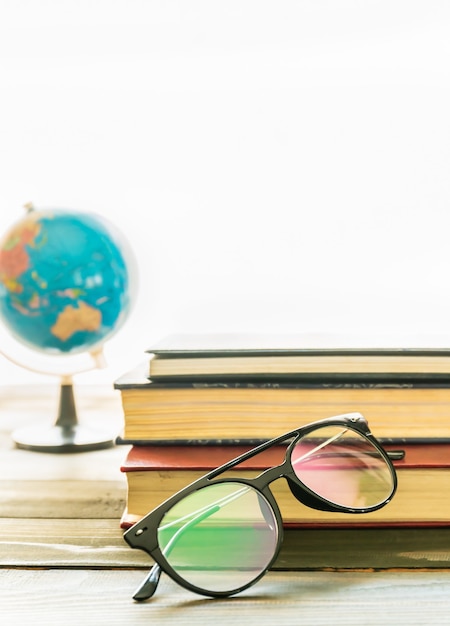 Gafas de lectura en libros de tapa dura sobre mesa de madera