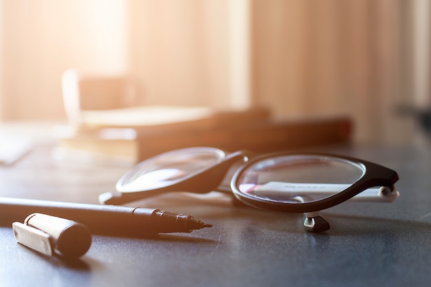 Foto gafas y libro sobre mesa de madera.